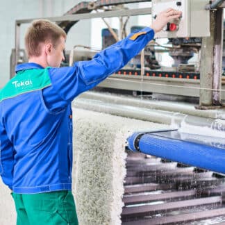Mitarbeiter wäscht Teppich mit automatischer Teppichwaschmaschine bei Tekal - Fotocredit: Ivan Kislitsin / Shutterstock.com